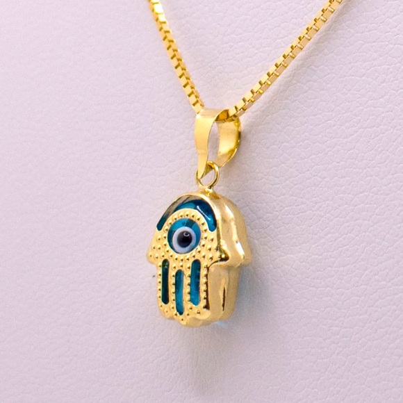Hamsa pendant with a blue stone paired with a necklace. - Picture 3 of 3